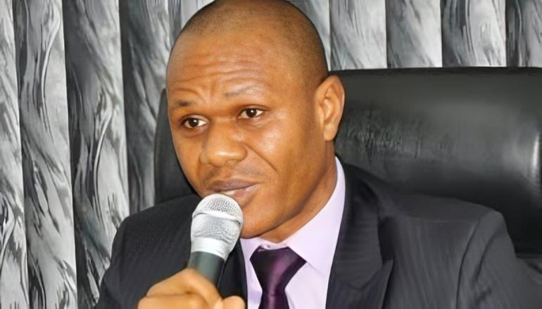 EFCC spokesperson Wilson Uwujaren holding a microphone while giving an official statement.