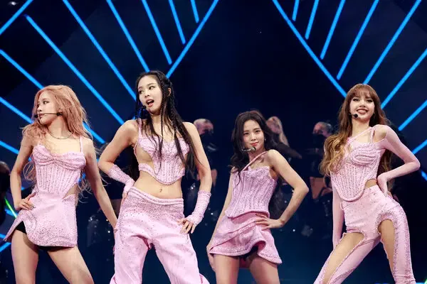 The four members of K-pop group BLACKPINK (Jisoo, Jennie, Rosé, and Lisa) performing a choreographed routine on stage.