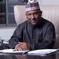 Abdulsamad Rabiu, the second-richest man in Africa and BUA Group Chairman, seated at his desk in a professional office setting.