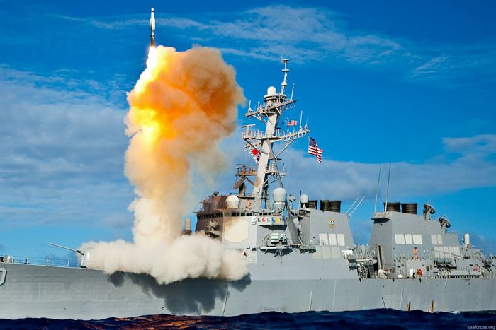 An Arleigh Burke-class guided-missile destroyer, like the USS Mason, launching a vertical interceptor missile from its deck during a naval engagement.