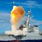 An Arleigh Burke-class guided-missile destroyer, like the USS Mason, launching a vertical interceptor missile from its deck during a naval engagement.