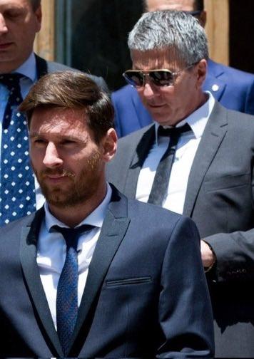 Lionel Messi standing in front of his father, Jorge Messi
