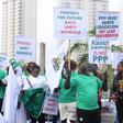 group of Nigerian alumni and protesters holding placards with "Protect the Future, Save Unity Schools" and "Asset Stripping is Not PPP" written on them.