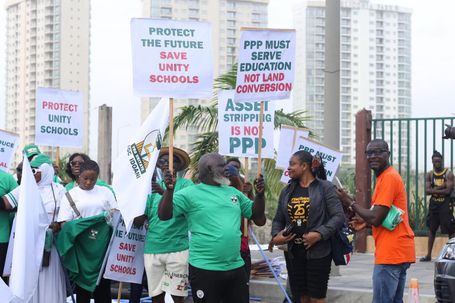 group of Nigerian alumni and protesters holding placards with "Protect the Future, Save Unity Schools" and "Asset Stripping is Not PPP" written on them.