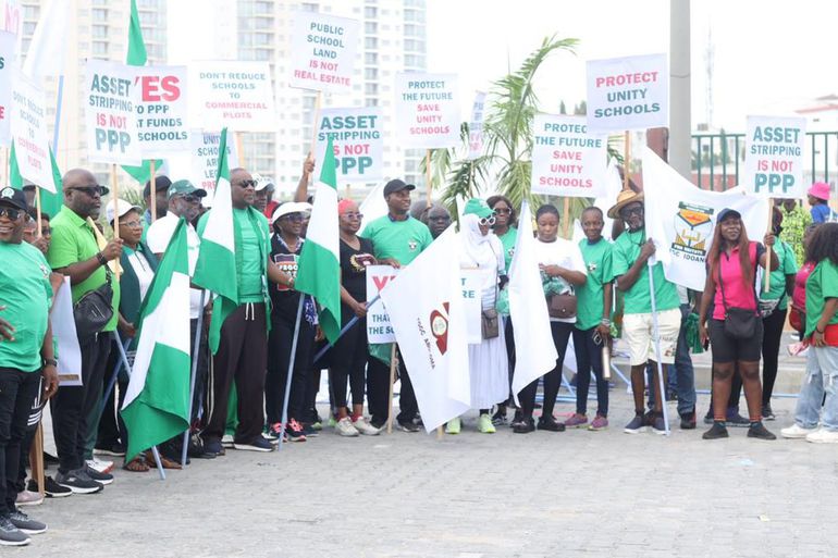 A group of Nigerian alumni and protesters holding placards with "Protect the Future, Save Unity Schools" and "Asset Stripping is Not PPP" written on them.