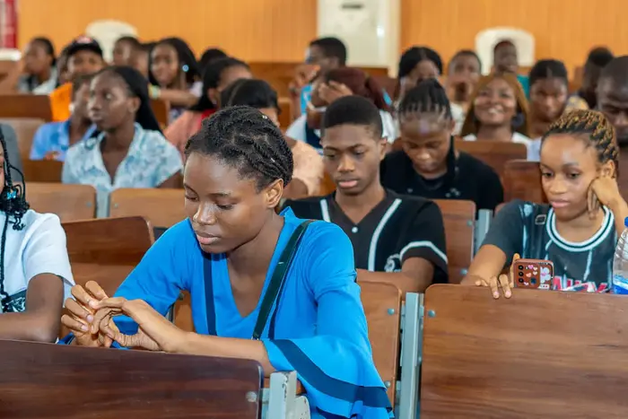 Nigerian university students in a lecture hall focusing on theoretical coursework.