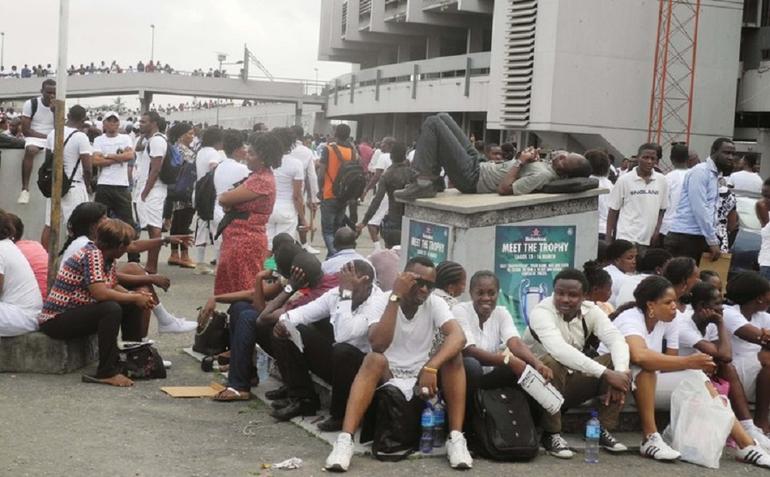 A large group of Nigerian job seekers waiting outside a stadium for a recruitment exercise.