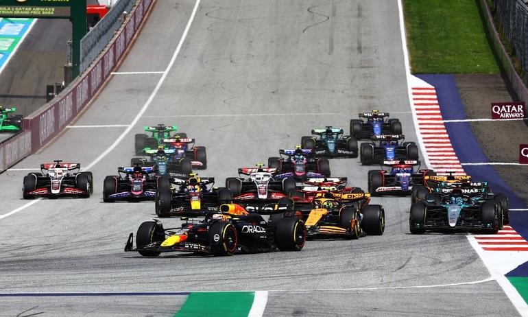 The Formula 1 grid thunders through the opening lap of a Grand Prix.