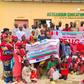 NDLEA officials and students of At-Ta'awuun Educational Services posing with "War Against Drug Abuse" banners during a drug awareness campaign in Nigeria.