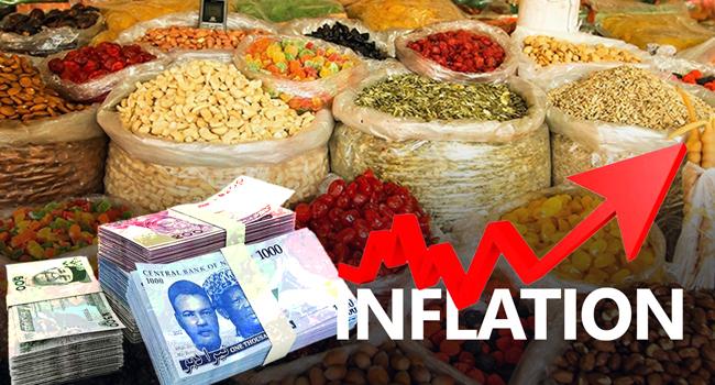 Nigerian Naira currency notes stacked in front of market food items with a rising red inflation arrow graphic.