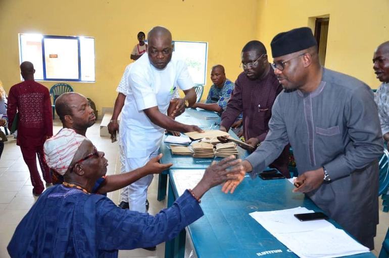 A senior citizen interacts with local government officials during a disbursement exercise for the elderly stipend scheme.