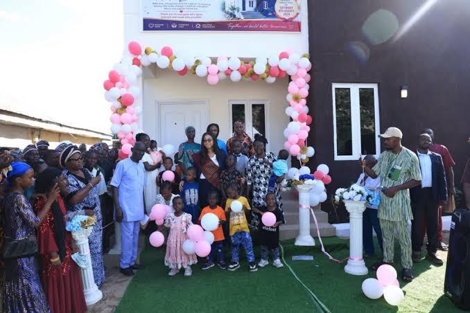 Nadia Zakaria, children, and guests gather outside the newly completed Oyiza-Salem Divine Orphanage complex in Etahi, Okene.