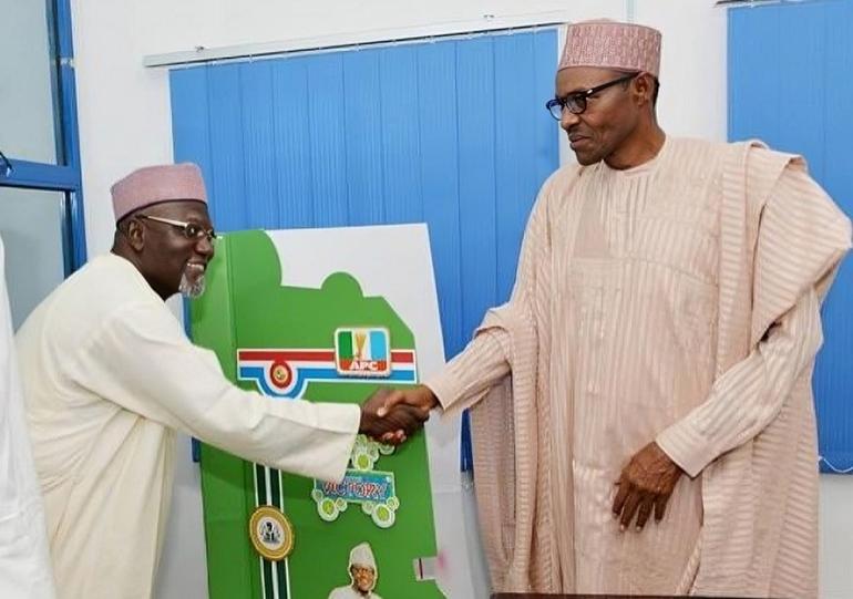 The late former President, Muhammad Buhari, shares a warm handshake with Lawal Daura