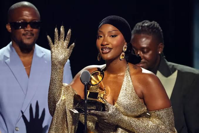 Grammy winner, Tems holding her award on stage