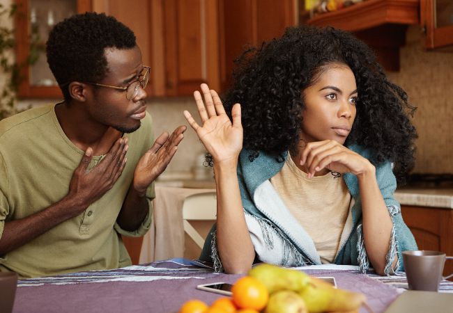 A black man trying to apologise to a woman