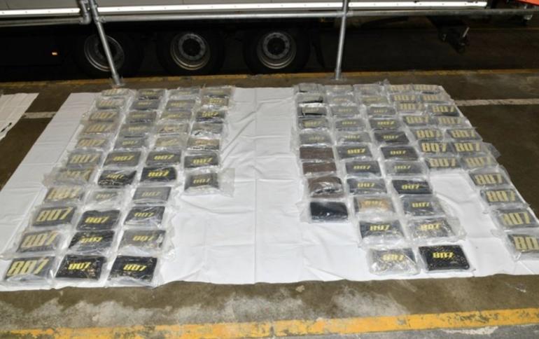 Ninety wrapped brick packages of seized cocaine laid out in rows on white plastic sheets on a garage floor during a UK National Crime Agency investigation.