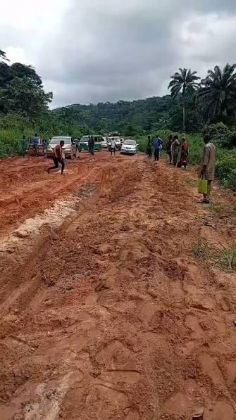 Motorists and pedestrians struggle to navigate the deep mud and poor driving conditions on Okhun Road.