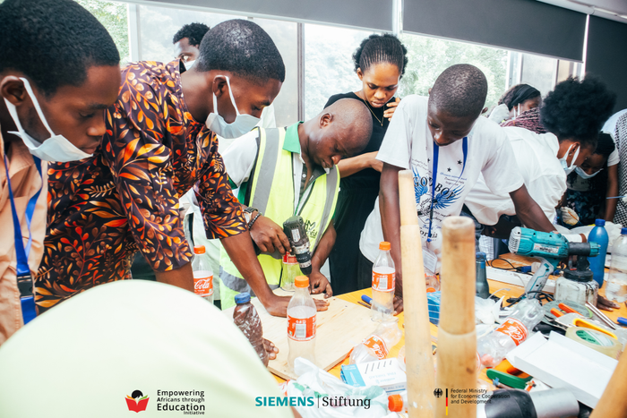 Nigerian youth getting practical vocational skills and engineering training using power tools during a BeMINT workshop.