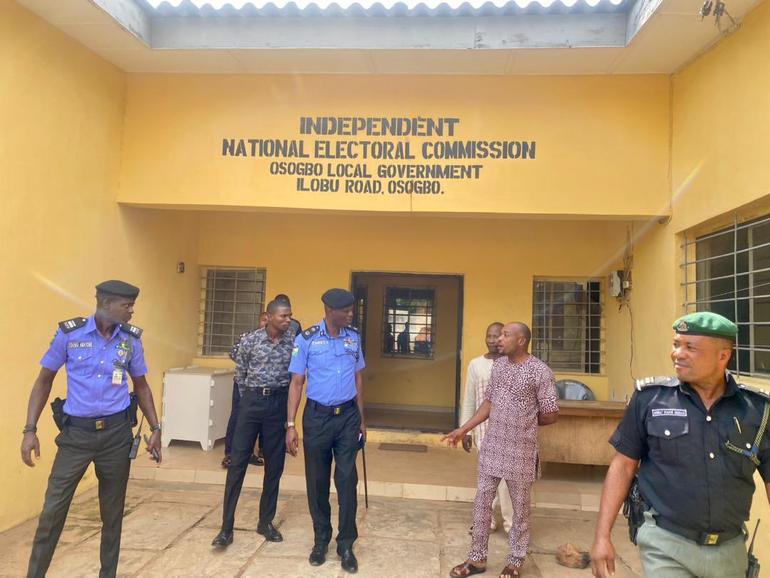 Security personnel and observers outside the INEC local government office in Osogbo amid rising political tensions over unclaimed PVCs.