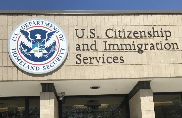 Exterior of a U.S. Citizenship and Immigration Services office building showing the official DHS seal.