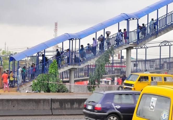 Pedestrians use a covered pedestrian bridge to cross a busy highway safely in Lagos, Nigeria.