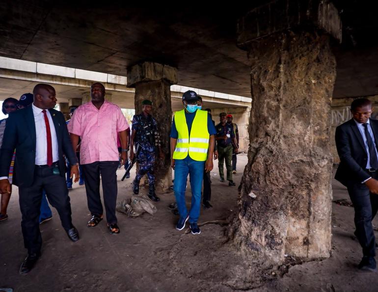 Governor Babajide Sanwo-Olu and other government officials conduct a site inspection of a bridge where the concrete pillars have been heavily damaged by suspected vandals.