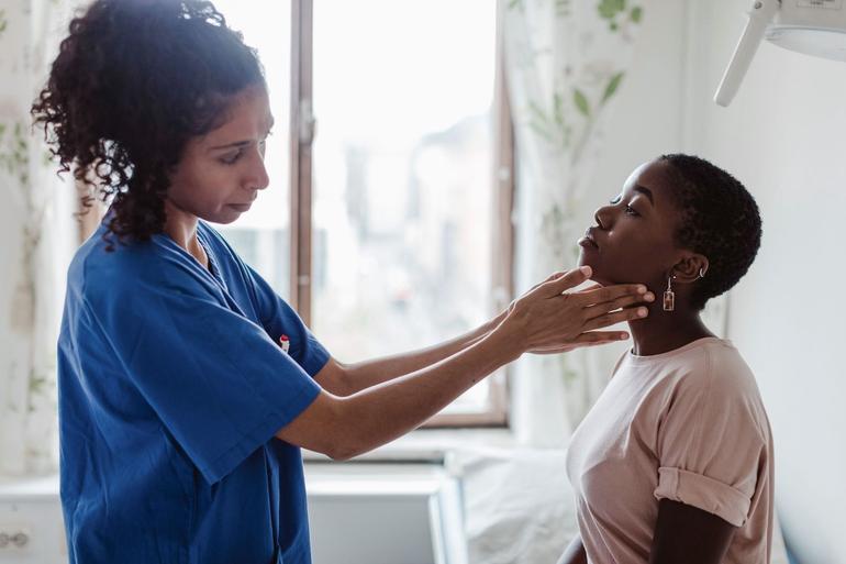 A doctor checking a patient's neck for lumps