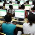 Dozens of Nigerian students are sitting in rows in front of desktop computers, taking the UTME exam at an official JAMB CBT centre. 