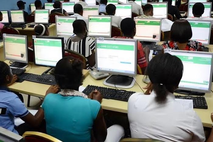 Dozens of Nigerian students are sitting in rows in front of desktop computers, taking the UTME exam at an official JAMB CBT centre. 