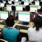 Dozens of Nigerian students are sitting in rows in front of desktop computers, taking the UTME exam at an official JAMB CBT centre. 