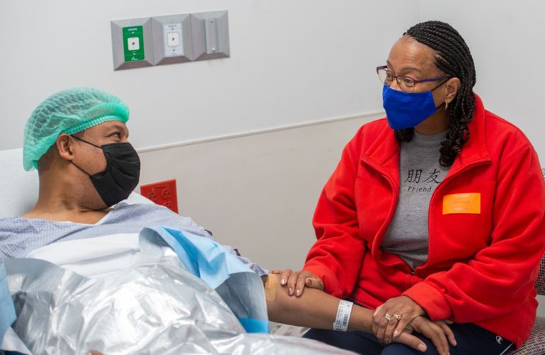 a couple holding hands in a hospital setting, symbolising support during a kidney donation journey.
