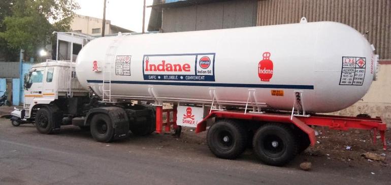 A large white LPG bulk storage tanker truck used for distributing cooking gas from supply depots to retail stations.