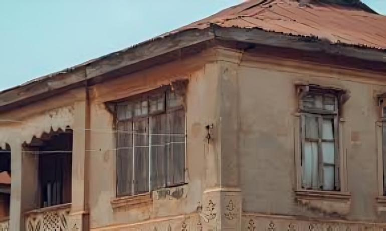 An old residential building with a rusted zinc roof in Lagos, symbolizing the housing deficit and rental market struggles in Nigeria.