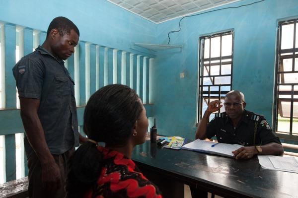 Nigeria Police Force officer taking a statement from a complainant