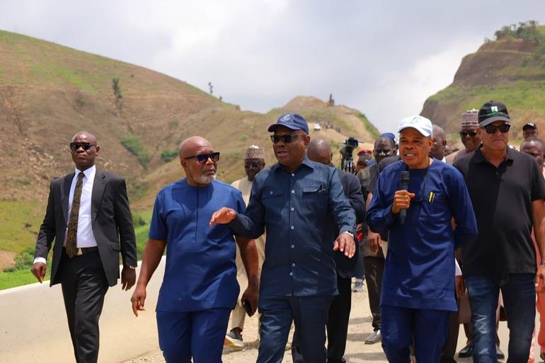 FCT Minister Nyesom Wike walking with officials during an inspection of ongoing Abuja road construction projects.