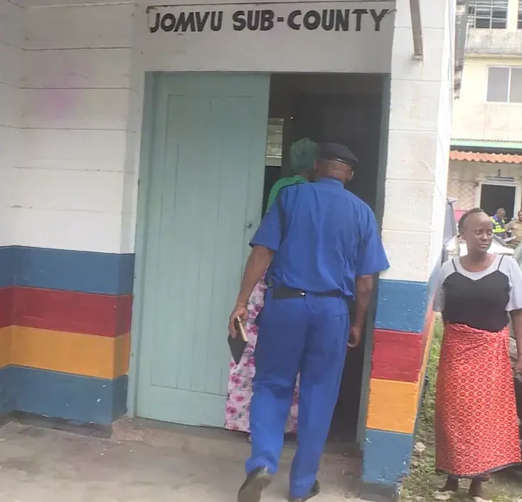 Police leading the mother into a police cell in Jomvu, Mombasa County