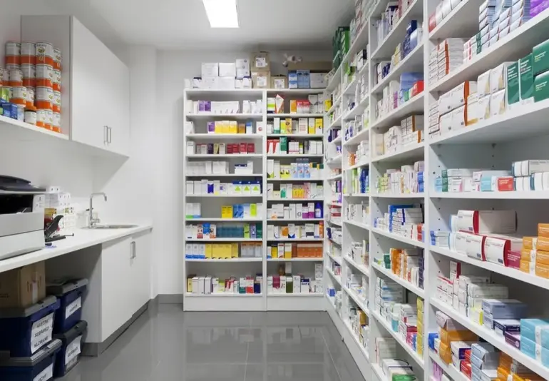 Clean and well-organized shelves stocked with genuine medicines inside a registered and licensed pharmacy.