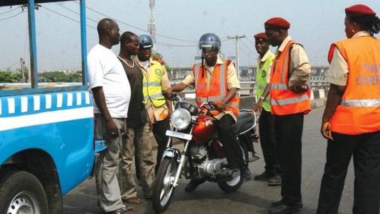 FRSC officials in Nigeria impounding a commercial motorcycle okada during a traffic enforcement operation on a highway.