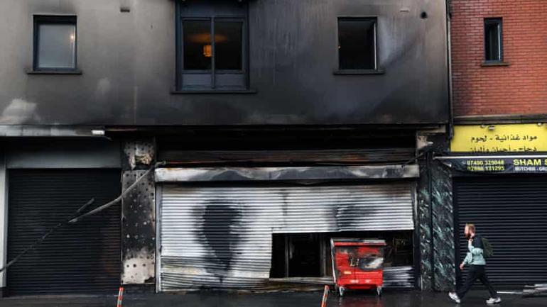The remains of a torched grocery store and damaged flats in central Belfast on Wednesday. Photograph: Peter Morrison/AP