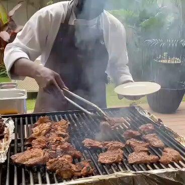 A picture of a man grilling some meat