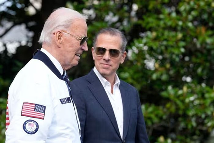 President Joe Biden, wearing a Team USA jacket and walking with his son Hunter Biden, heads toward Marine One on the South Lawn of the White House in Washington, July 26, 2024. (AP)