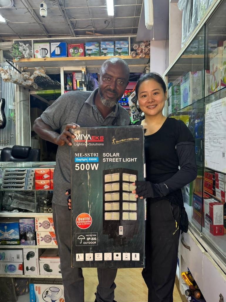 Businessman Chabari Hon Alpha displays a solar lamp with an associate at his electrical shop in Malindi Town (Image: Facebook)