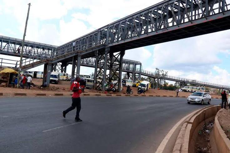 A person crossing the road instead of using a footbridge