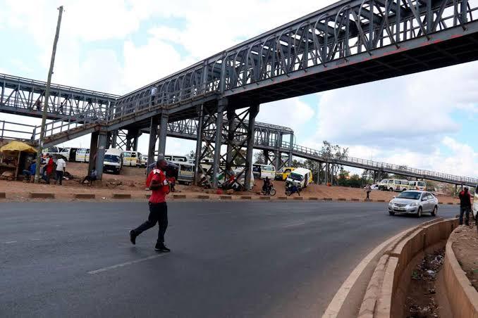 A person crossing the road instead of using a footbridge