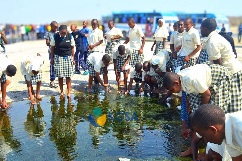 Kibera Girls Soccer Academy students wash their faces and feet in Lake Magadi's unique mineral-rich waters during an education trip to the salt factory (Image: Files)