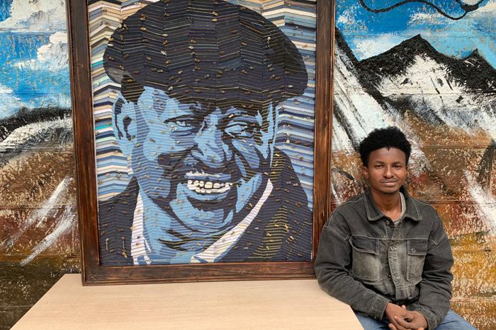 George Njenga, also known as Tetra G, alongside his artpiece of the late former Prime Minister Raila Odinga