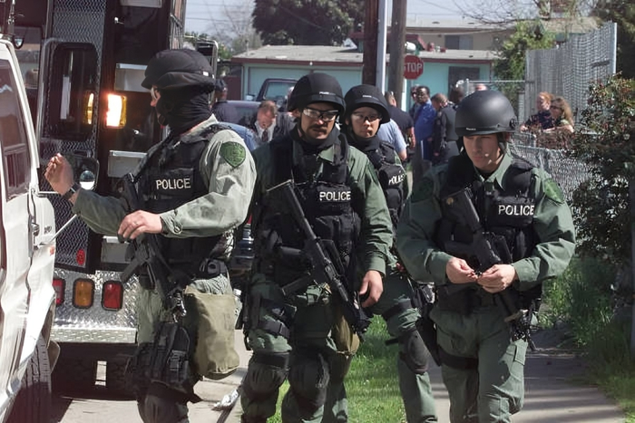A SWAT team prepares to surround a home in East Palo Alto, where a man was believed to be barricaded inside the home with weapons and potential hostages on Wednesday, March 14, 2001.