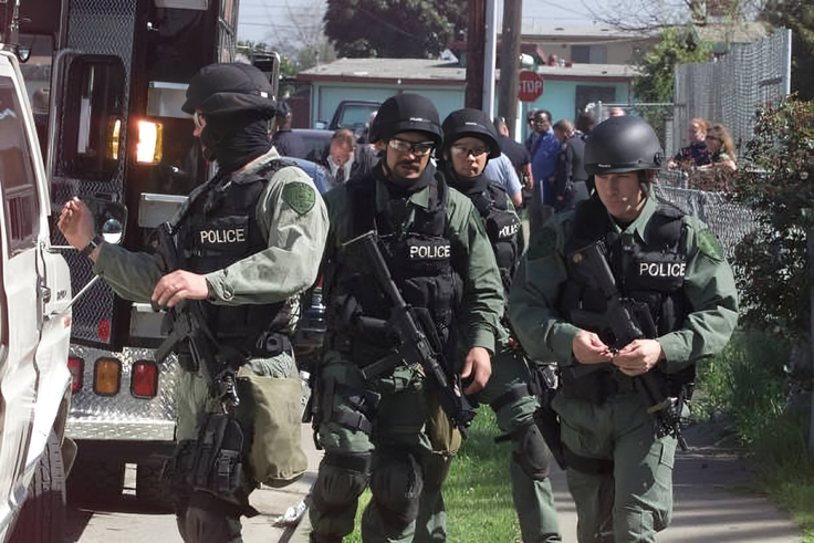 A SWAT team prepares to surround a home in East Palo Alto, where a man was believed to be barricaded inside the home with weapons and potential hostages on Wednesday, March 14, 2001.