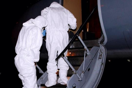 Health professionals wearing protective gear while transporting an Ebola patient. (Image: WHO)