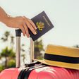 A person holding a suitcase and U.S. passport
